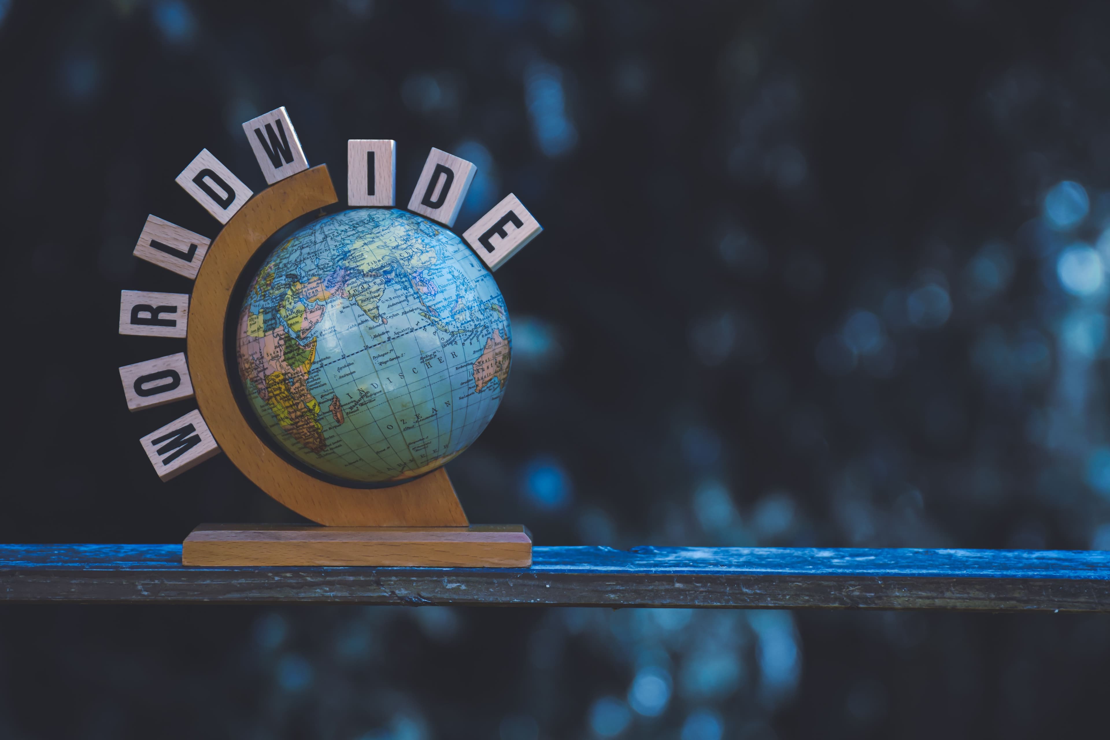 Wooden globe sculpture with worldwide text demonstrating global reach and international accounting services